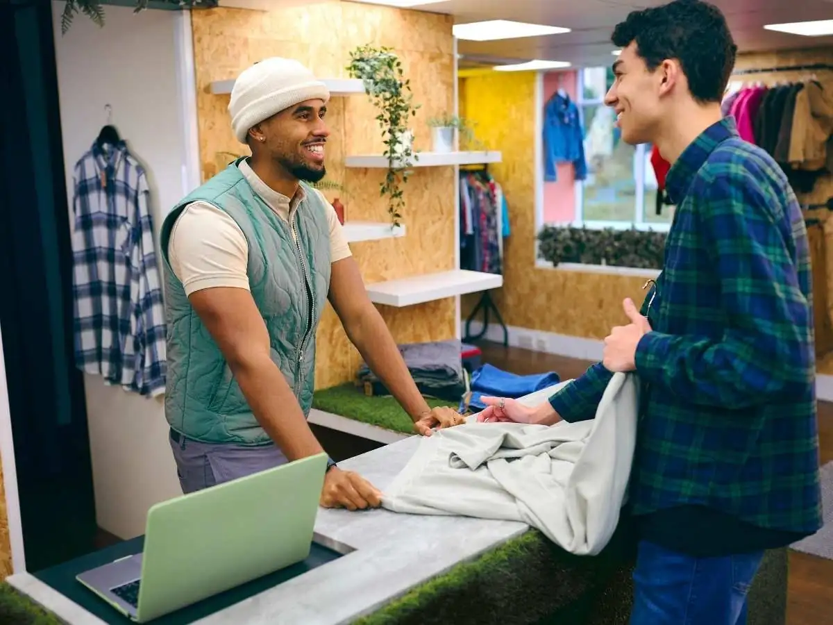 Shop owner serving a customer at the counter of a small store