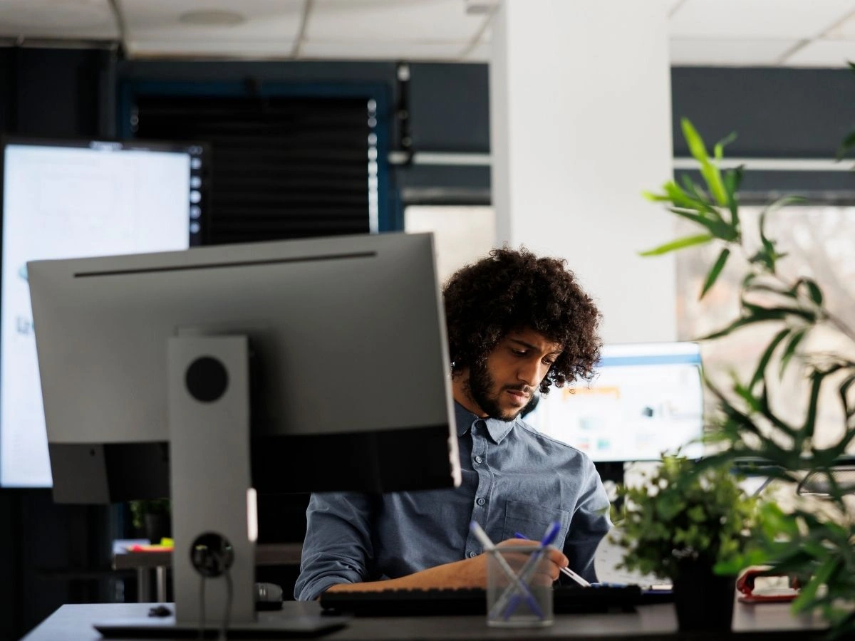 Business owner handling compliance paperwork at his office desk